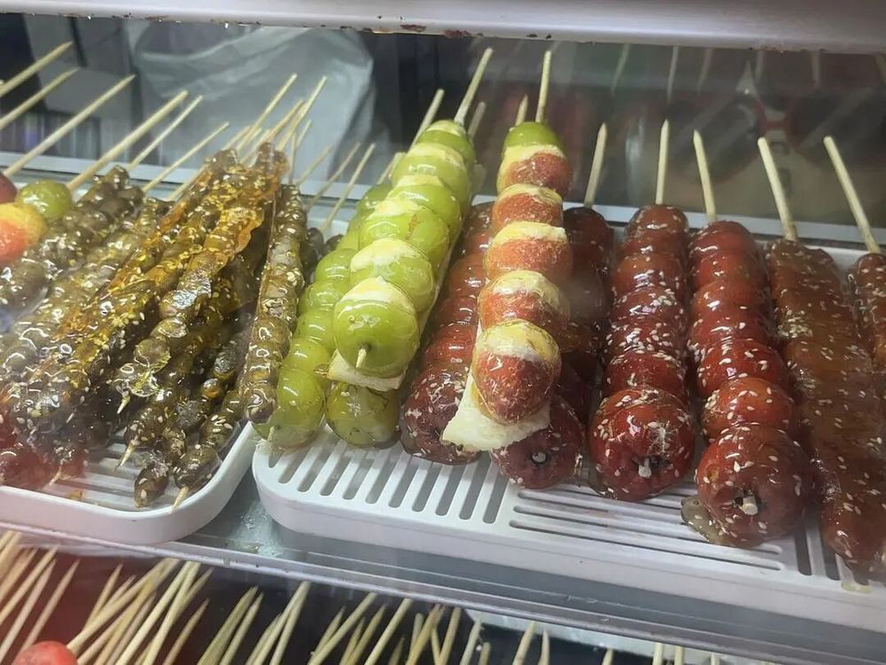 济南街头买“奶皮子糖葫芦”的队排了100多米,有店主忙得直冒汗:20元1串,一天卖两三百串