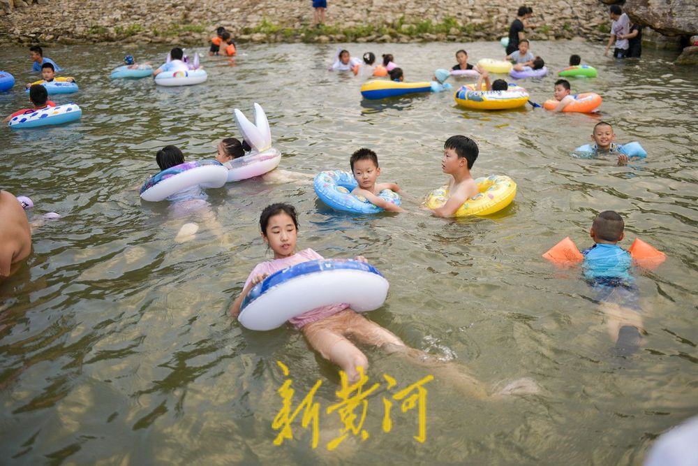 三伏天高温持续 滨水公园里戏水纳凉