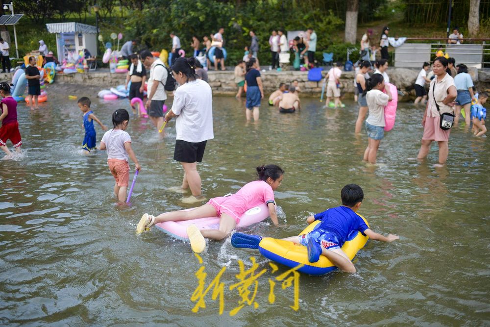 三伏天高温持续 滨水公园里戏水纳凉