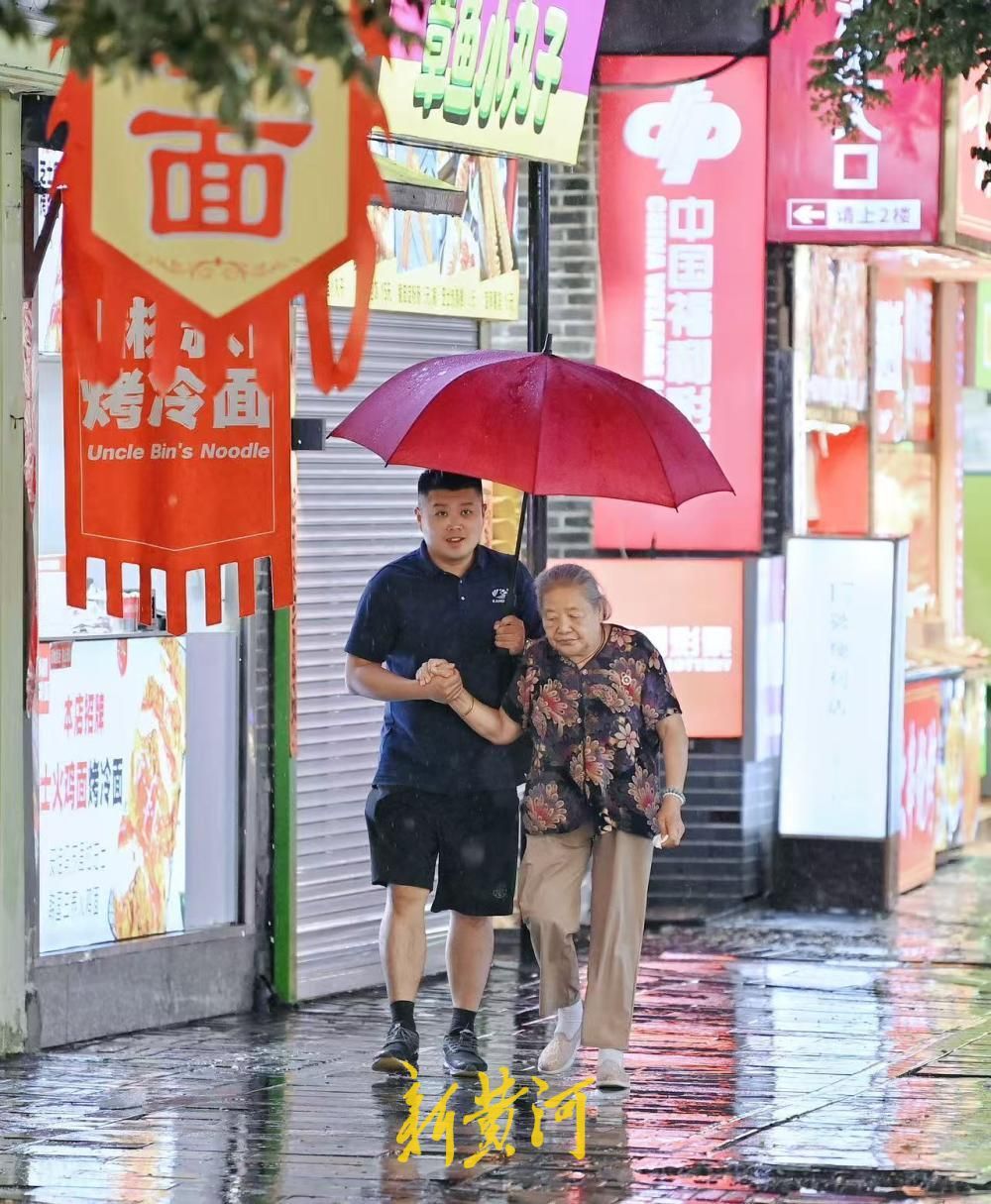 济南雨夜氛围感拉满 游客撑伞逛吃宽厚里