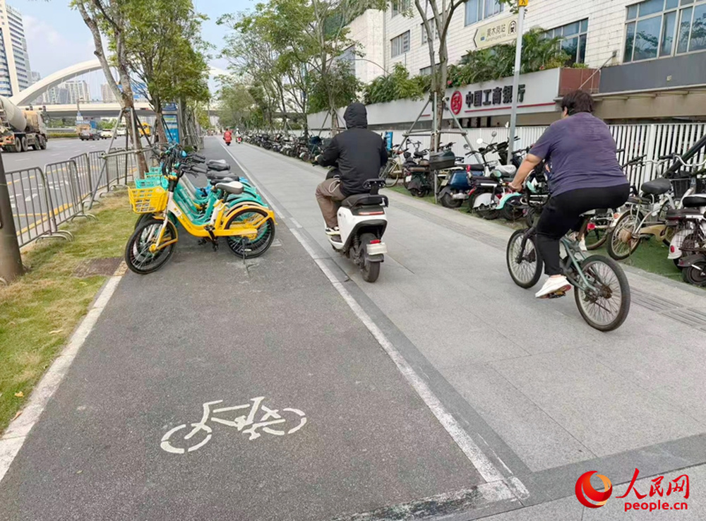深圳福田区华富街道，非机动车道（图中左侧）被共享单车阻断，非机动车被迫进入人行道骑行。人民网记者 王星摄