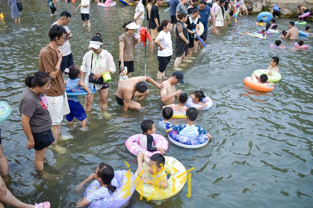 三伏天高温持续 滨水公园里戏水纳凉
