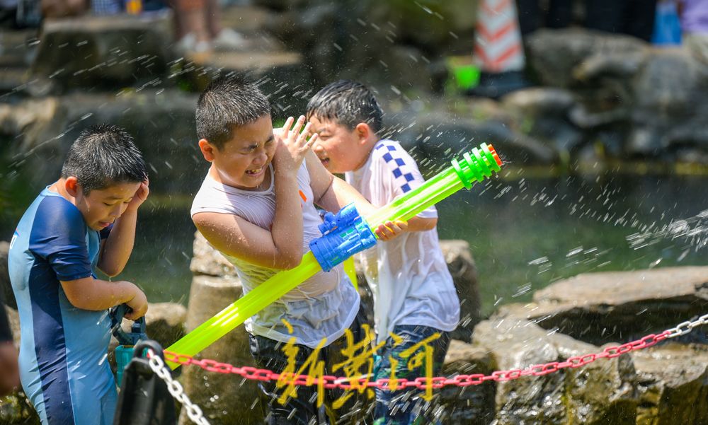 亲泉避暑济南市区这里最火！大人小孩穿着雨衣戏水纳凉