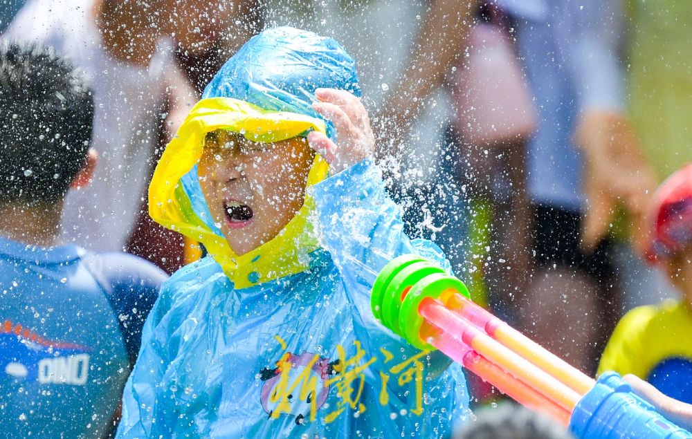 亲泉避暑济南市区这里最火！大人小孩穿着雨衣戏水纳凉