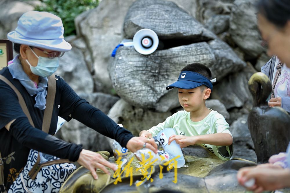 泉城高温持续 护城河畔泉水直饮点市民游客络绎不绝