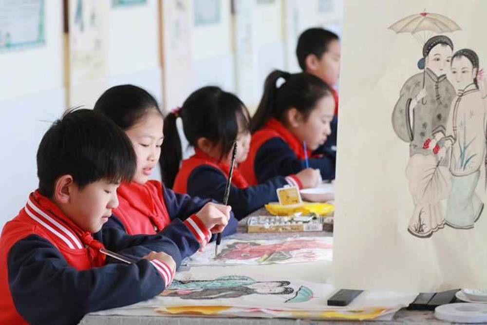 2-2026年3月16日 ,山东省高密市姜庄小学的小学生在美术课上绘制扑灰年画。(李海涛摄)