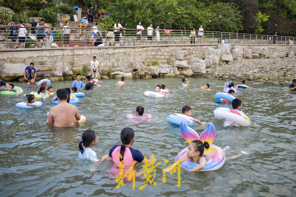 三伏天高温持续 滨水公园里戏水纳凉
