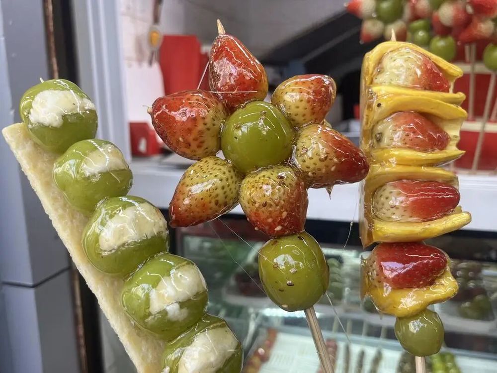 济南街头买“奶皮子糖葫芦”的队排了100多米,有店主忙得直冒汗:20元1串,一天卖两三百串