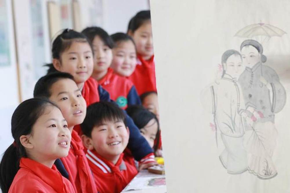 4-2026年3月16日 ,山东省高密市姜庄小学的小学生在美术课上聆听老师讲解扑灰年画的绘制技巧。(李海涛摄)