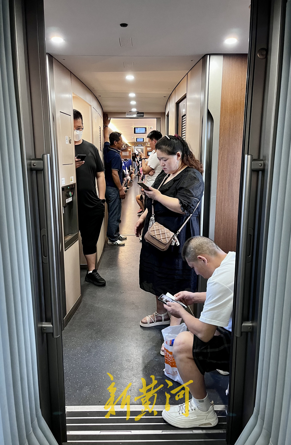 暑运客流高位运行高铁车厢内挤满无座乘客